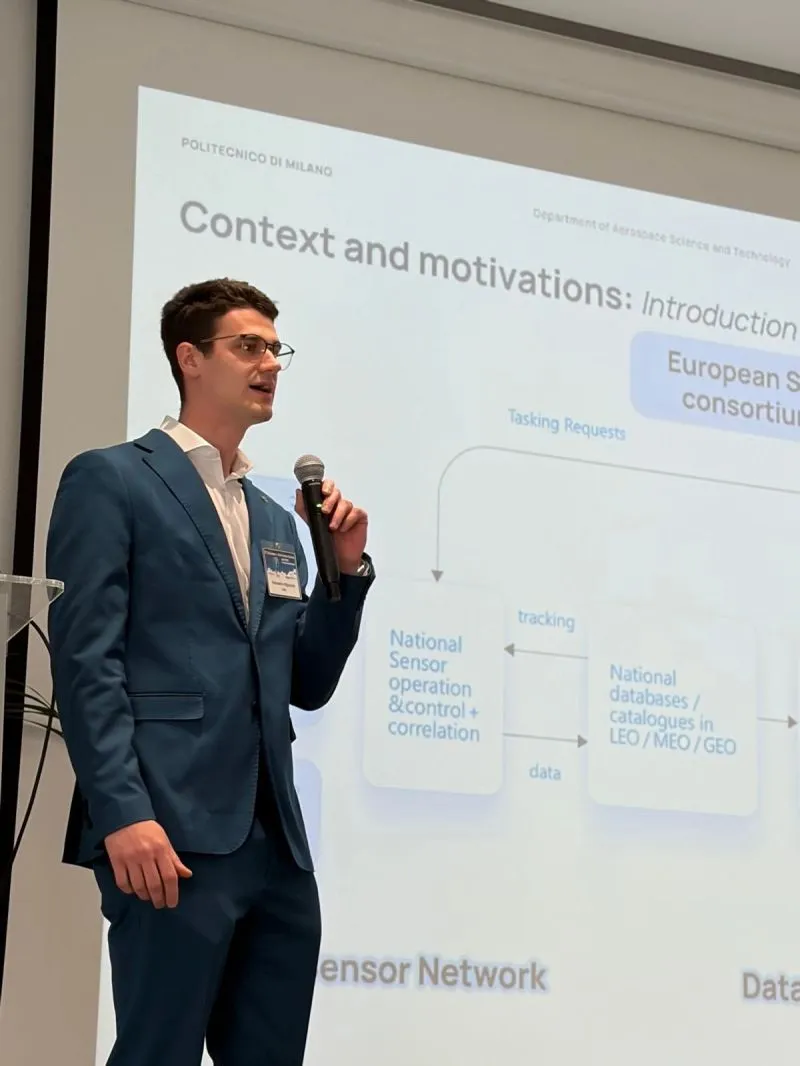 Alessandro presenting beside projected slides